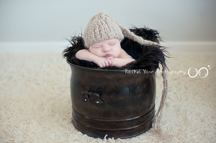 newborn baby photography - baby boy propped in a bucket