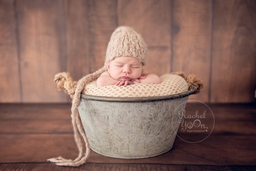 newborn baby in a metal bucket with a hat - Newborn Photography Vancouver