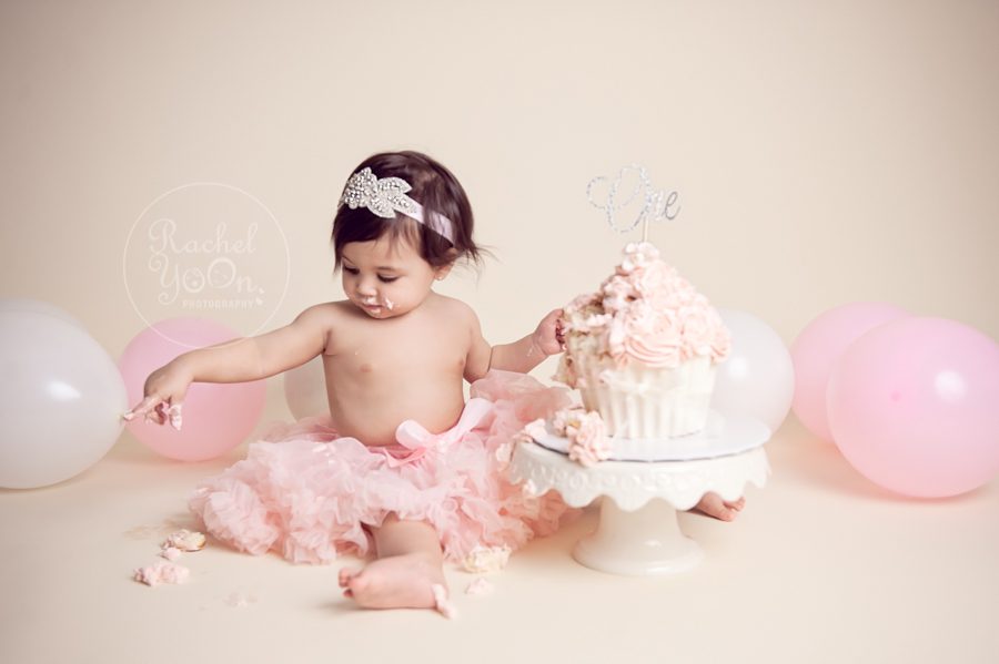 1 year old baby girl doing a cake smash - baby photography vancouver