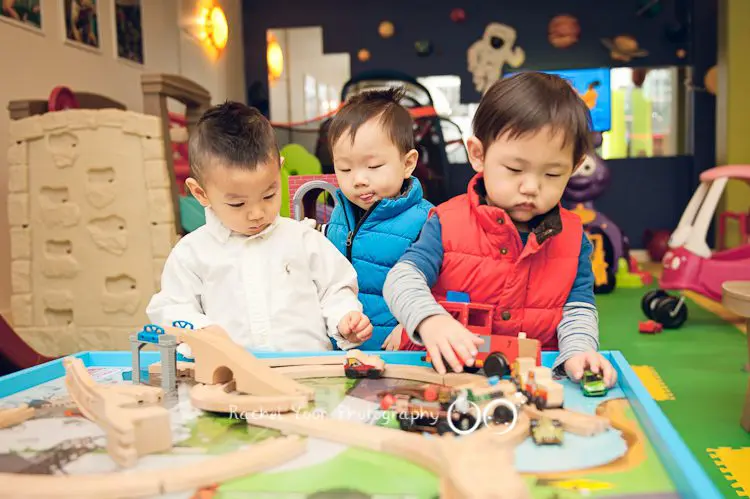 three boys playing with trains