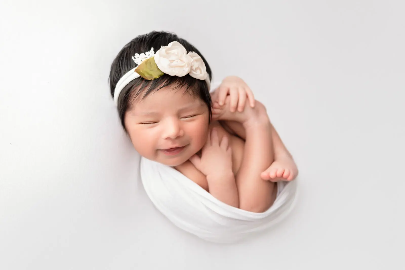 newborn baby girl wrapped in white