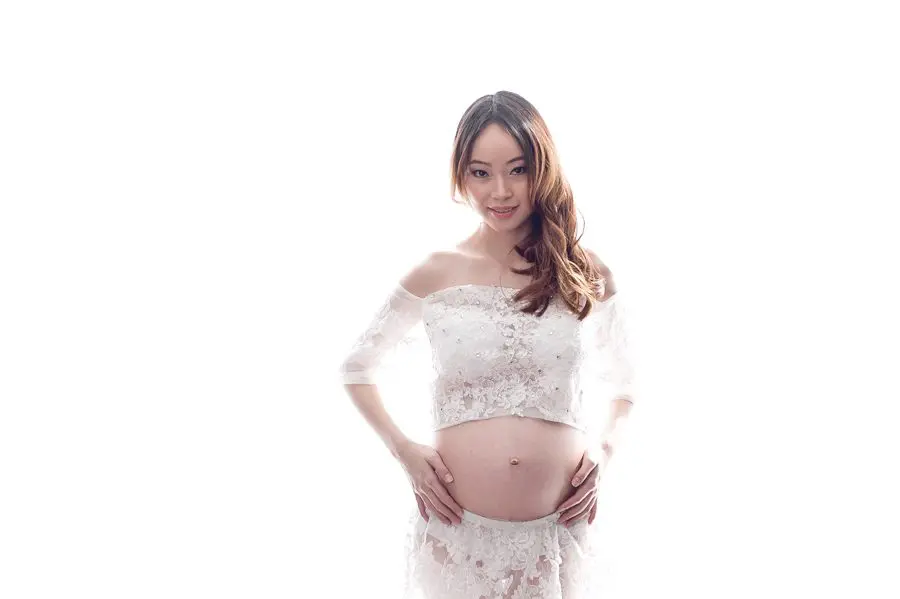 maternity pose in a lovely white dress with backlighting - maternity photography vancouver