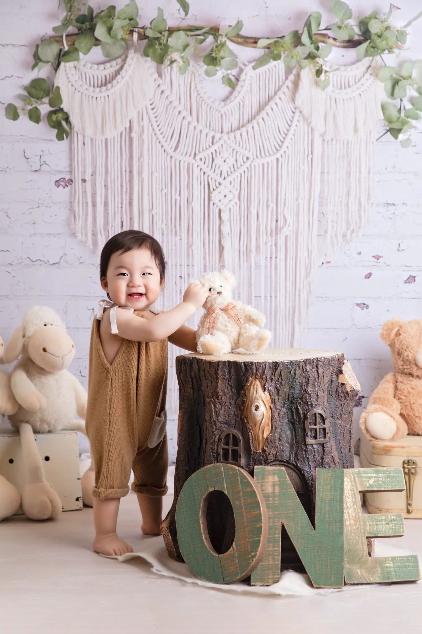 one year old baby boy standing next to the log