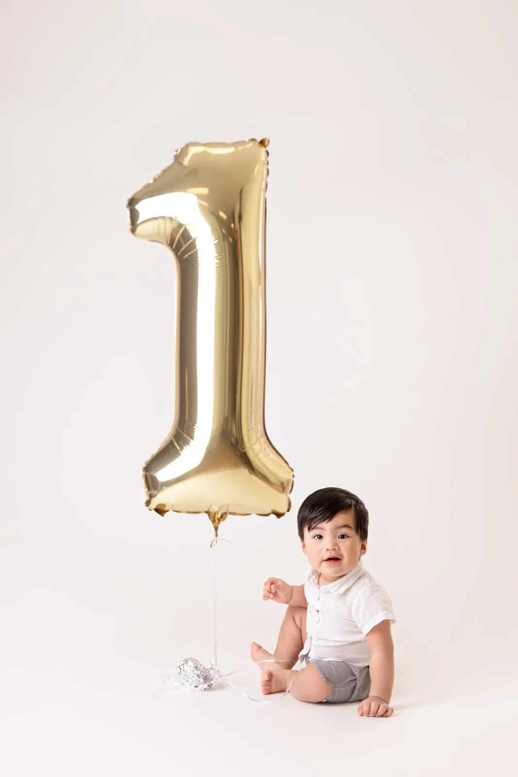 baby boy holding '1' balloon
