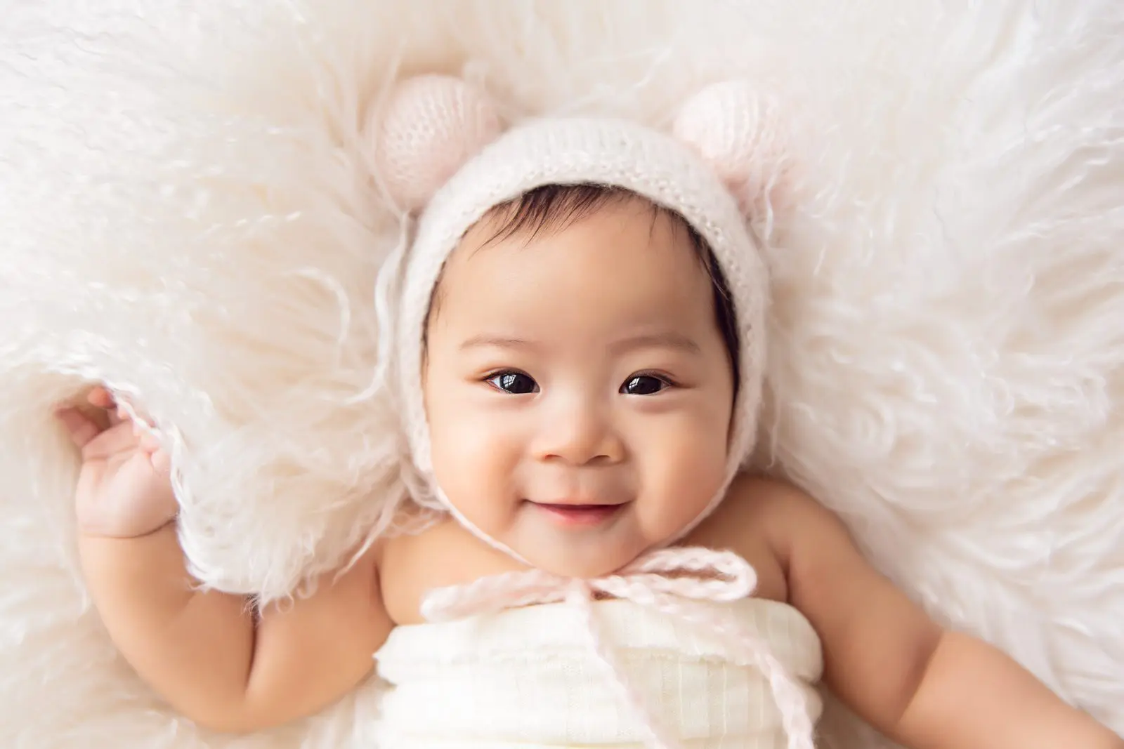 100 days old baby photography - baby girl with a pink bon bon bonnet