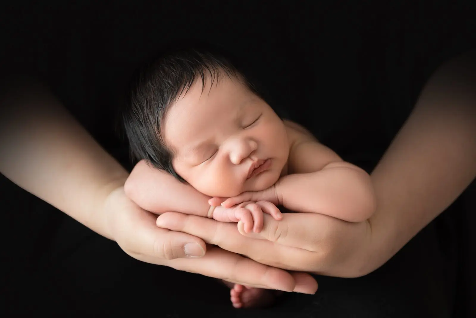 baby held on dad's hands