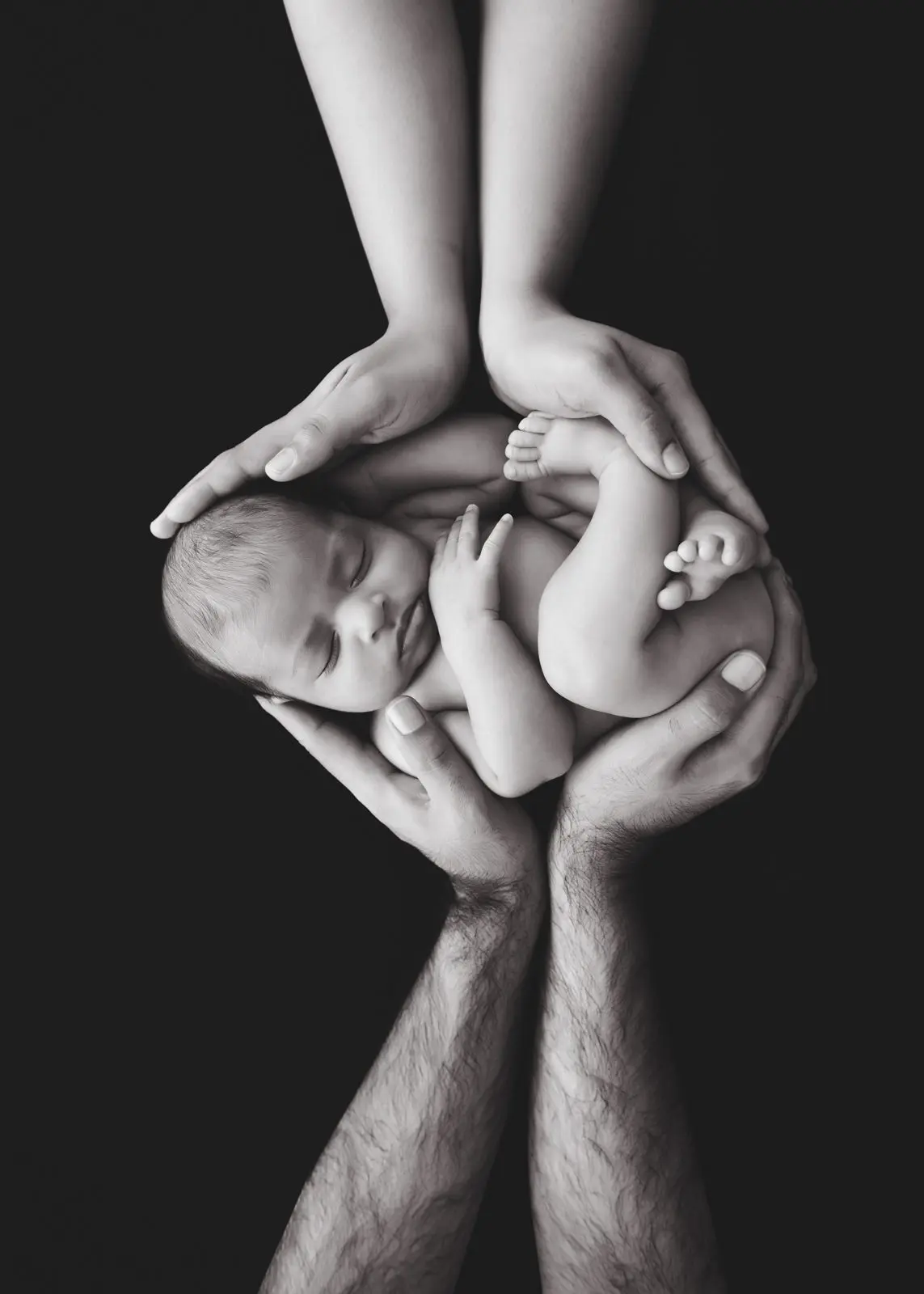 parents hands are wrapping around the baby