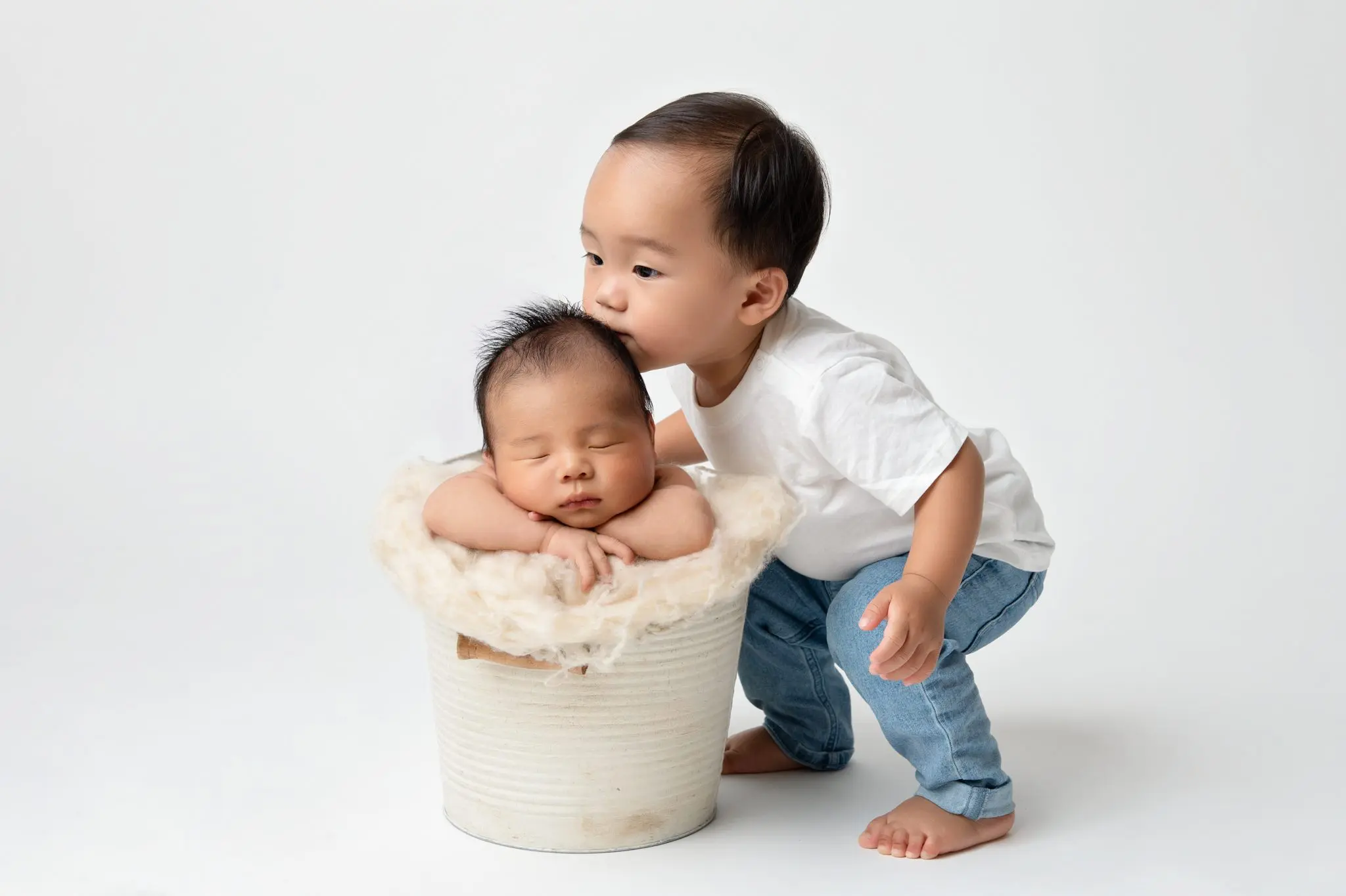 toddler kissing his baby brother