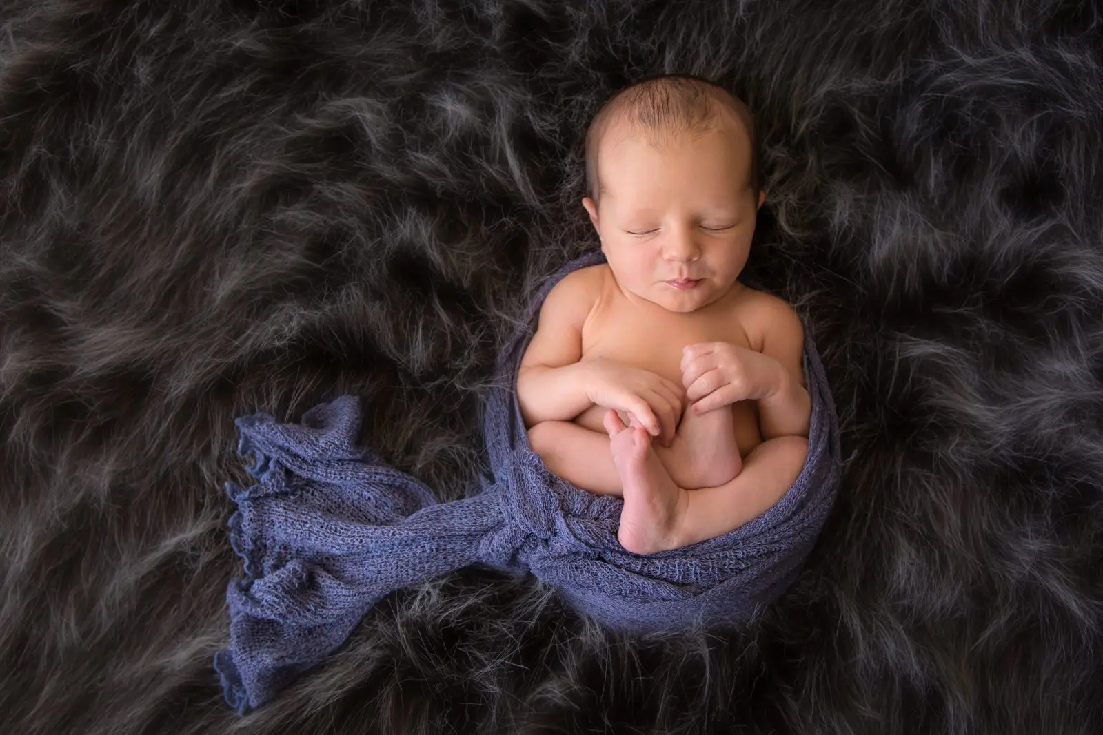 newborn baby in blue wrap