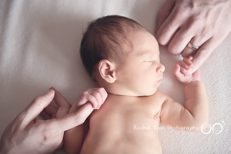 newborn baby holding parents' fingers