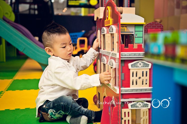 a boy playing with a toy house