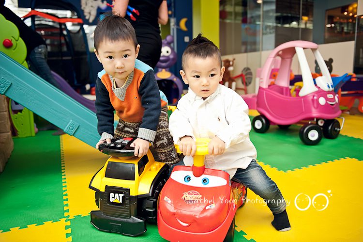 two boys riding a toy car