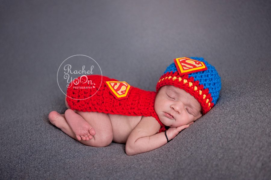 newborn baby boy in a bum up pose with superman outfit - newborn photography vancouver