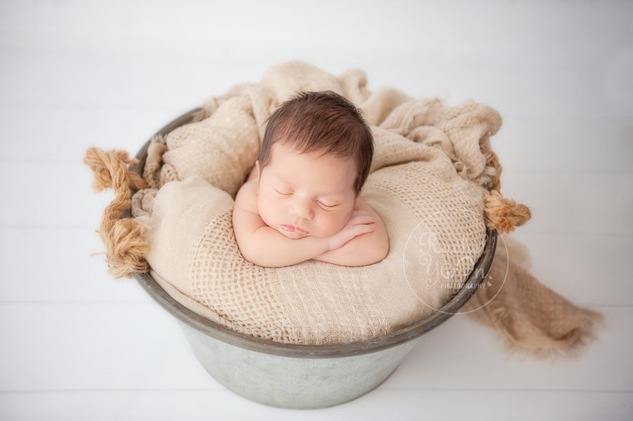 newborn baby in a metal basket
