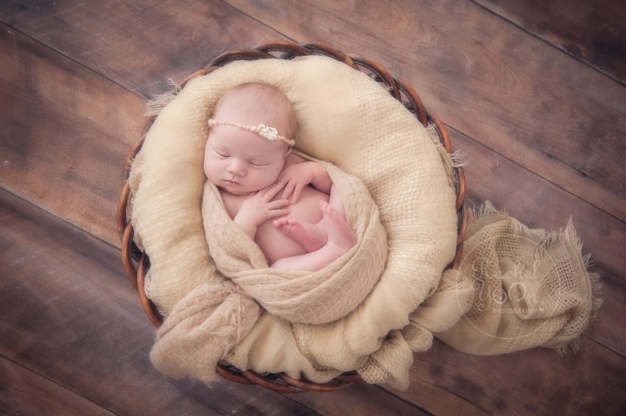newborn baby girl lying in a brown basket - newborn photography vancouver