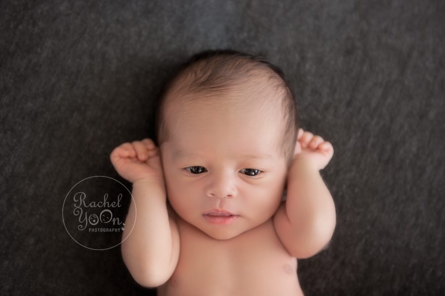 newborn baby boy with open eyes on a beanbag - newborn photography vancouver