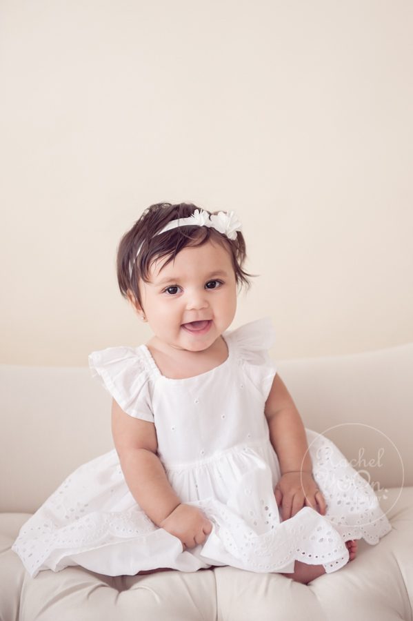 6 months old baby girl smiling in a white dress - baby photography vancouver