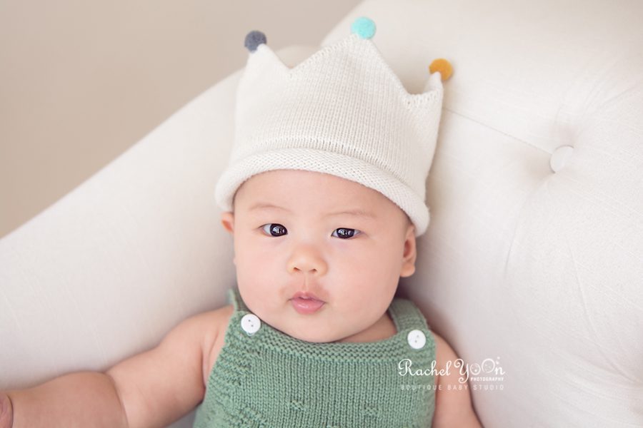 baby sitting with a beige crown hat - Vancouver Baby Photography for 100 days
