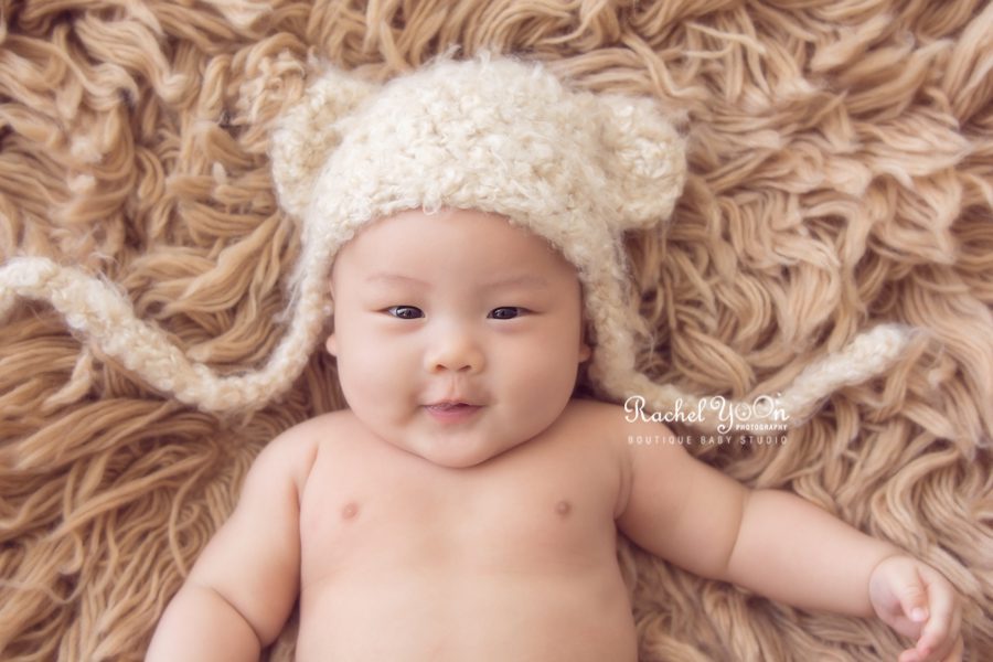 baby boy with a bear hat smiling - Vancouver Baby Photography for 100 days