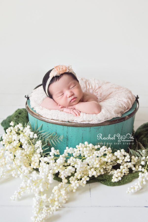 newborn baby girl in basket - decorated with flowers