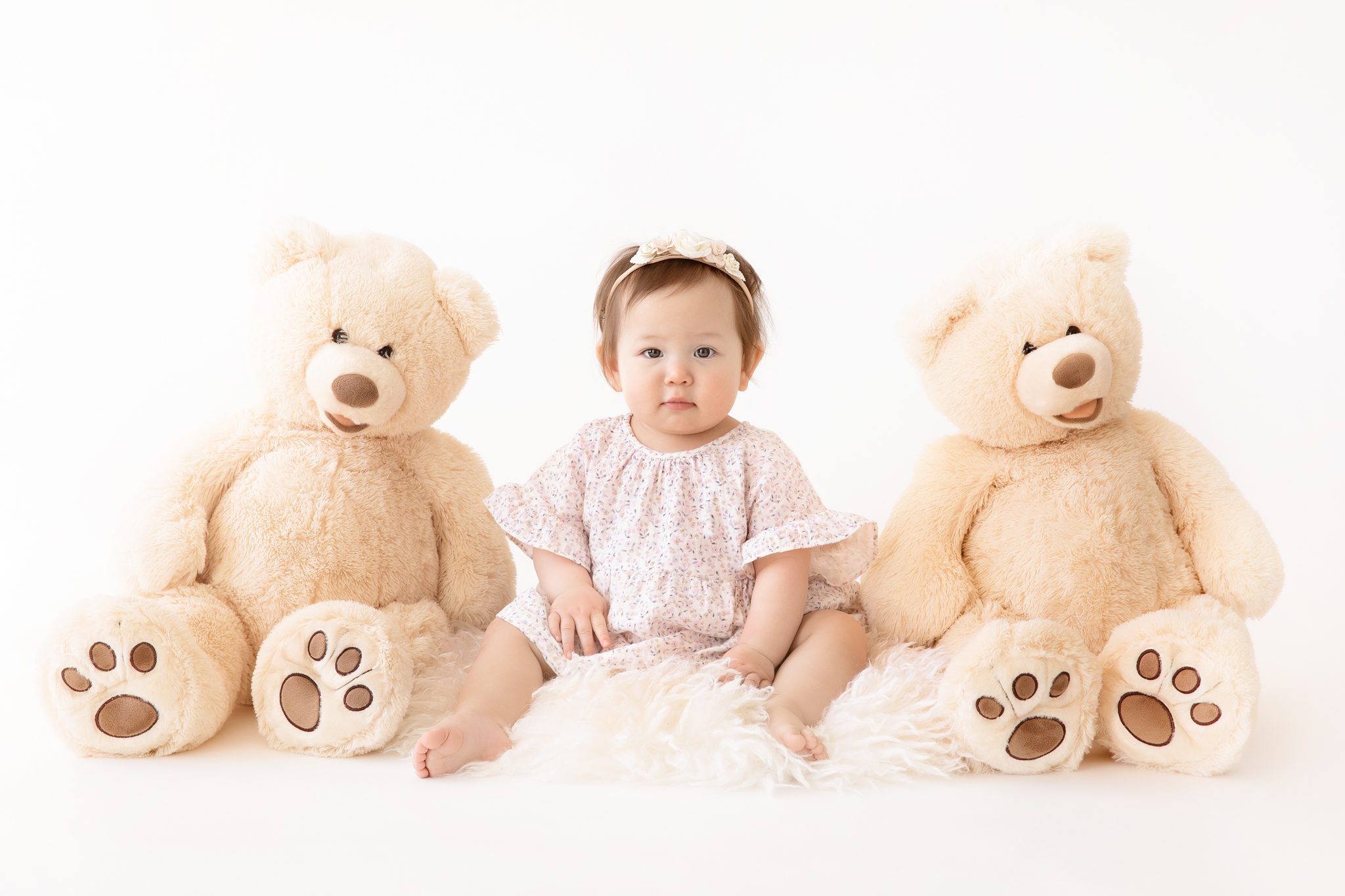 baby girl sitting with teddy bearas