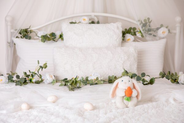 Easter sitter mini session theme with a white bed