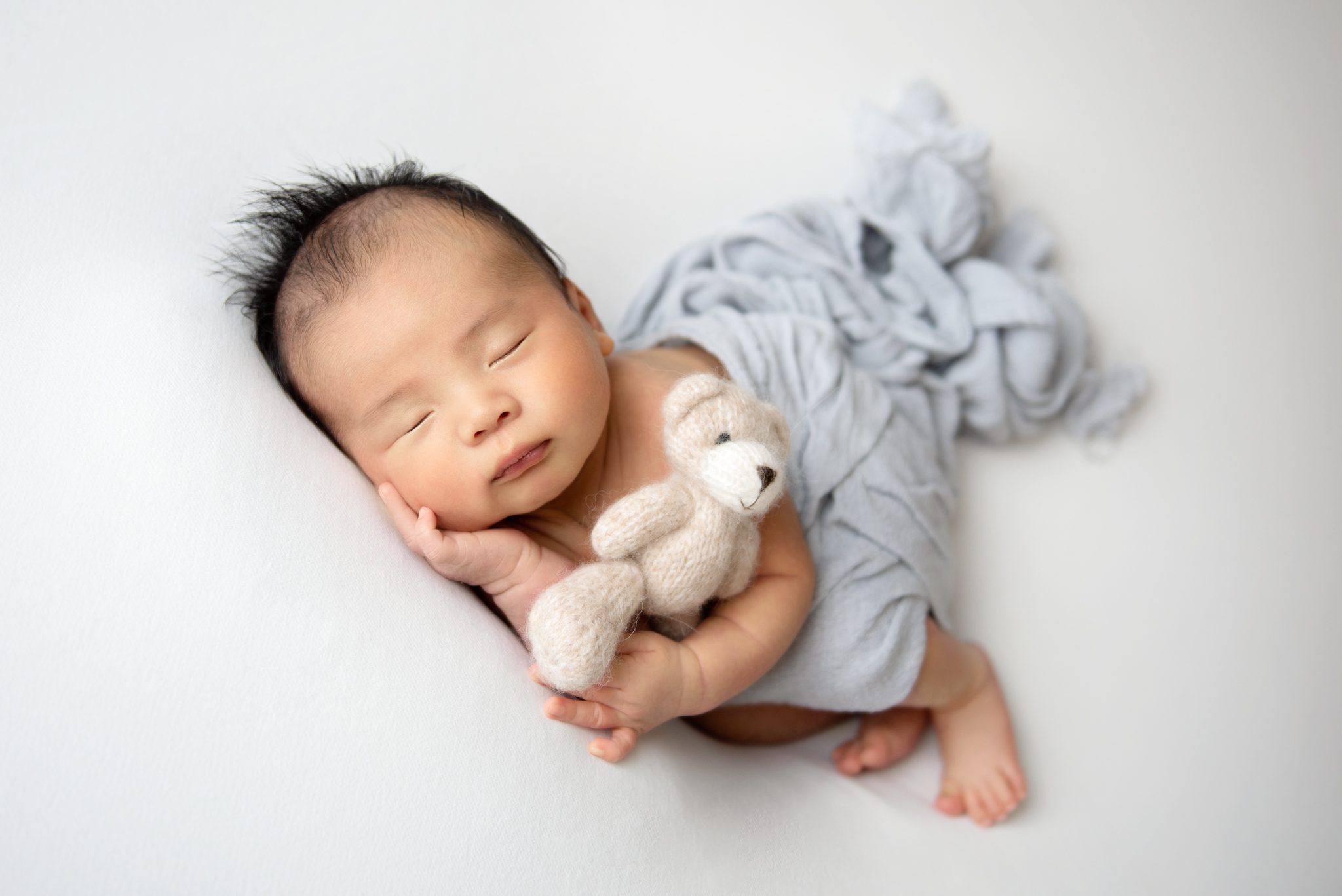 newborn baby boy holding a stuffy